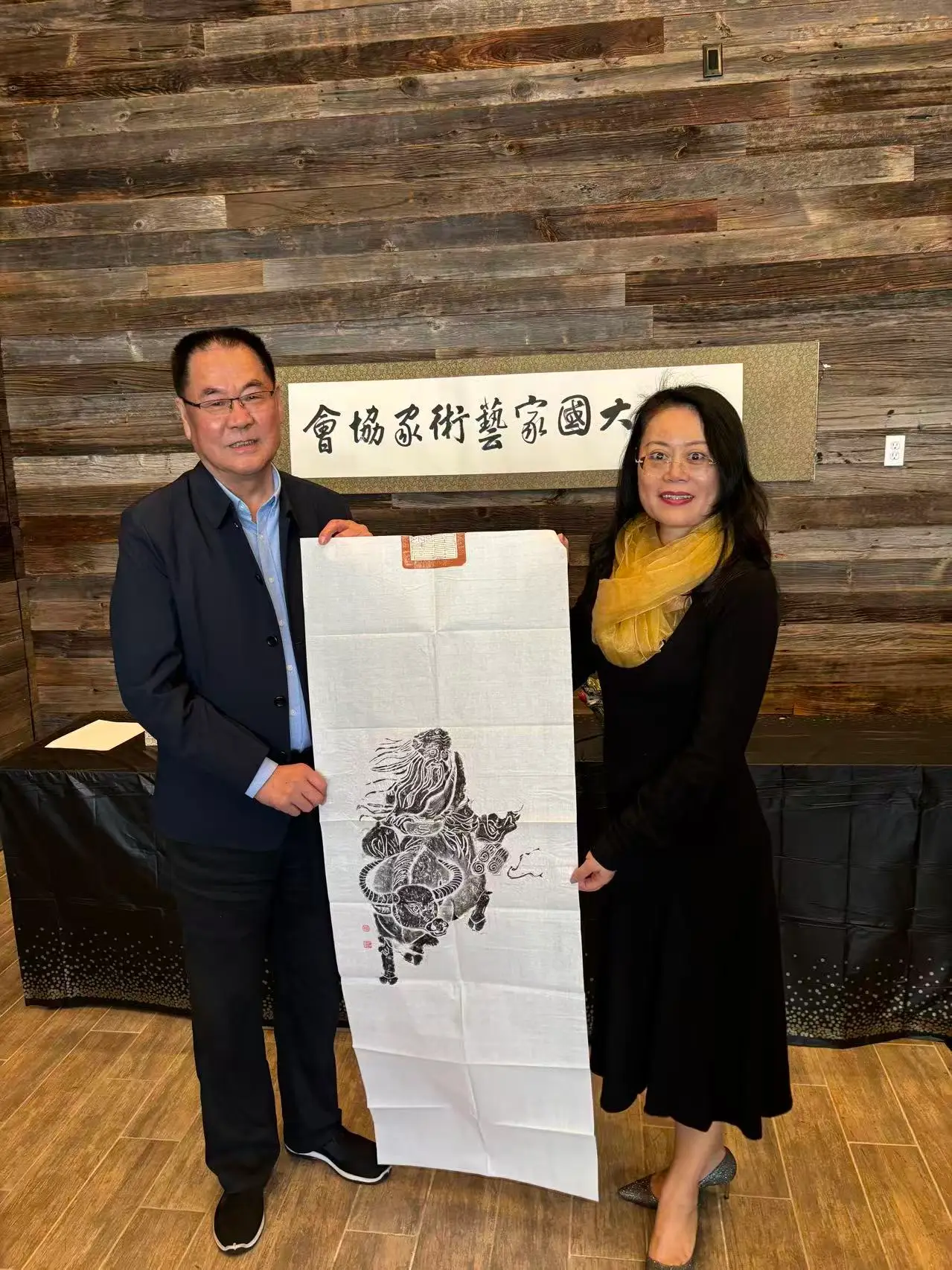 A painter presents an ink painting to the Association