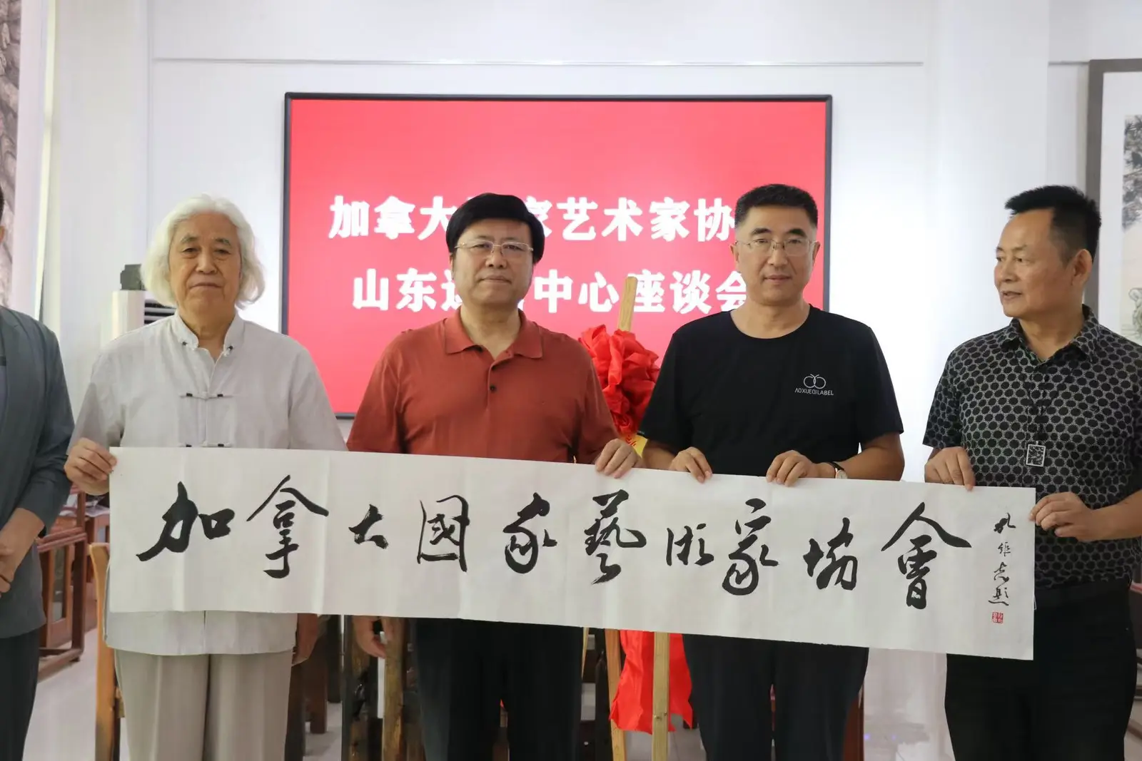 Association members holding a calligraphy scroll